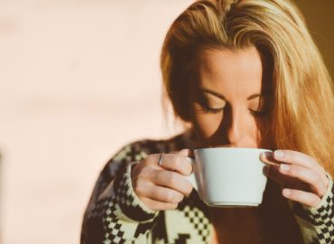 Mulher loira segurando uma xícara de chá